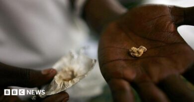 An individual holds a nugget of gold in his palm