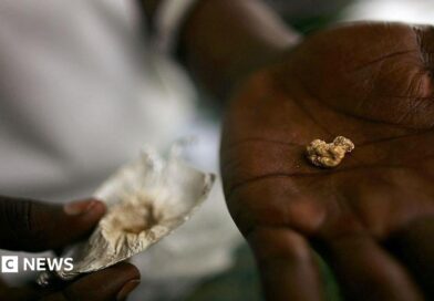An individual holds a nugget of gold in his palm