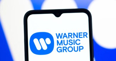 In this photo illustration, the Warner Music Group logo is seen displayed on a smartphone screen.