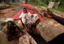 An informal gold miner holds up a rock recovered from inside a gold mine before it is ground down for processing at the site of Nsuaem-Top, Ghana