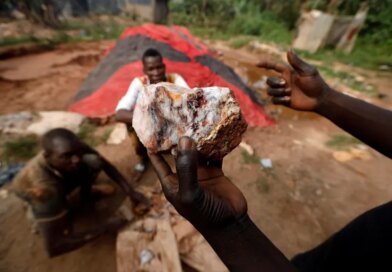 An informal gold miner holds up a rock recovered from inside a gold mine before it is ground down for processing at the site of Nsuaem-Top, Ghana
