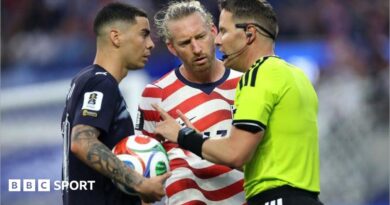 Referee Danny Makkelie speaks to the Miguel Almiron of Paraguay and USA defender Tim Ream during a VAR check for 'mistaken identify'