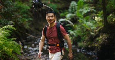 Man hiking in a forest wearing Odyssey camera pack