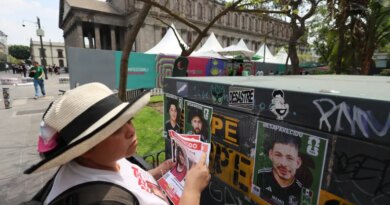 A member of the Colectivo Luz de Esperanza de Jalisco collective holds missing-person flyers near pasted signs featuring images of their loved ones who remain missing, displayed in a World Cup-style format, as part of the “Missing Persons World Cup Album" campaign to raise awareness of disappearances ahead of the 2026 FIFA World Cup, in Guadalajara, Mexico, May 31, 2026.  REUTERS/Michelle Freyria TPX IMAGES OF THE DAY