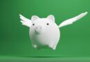 white piggy bank with wings on green background