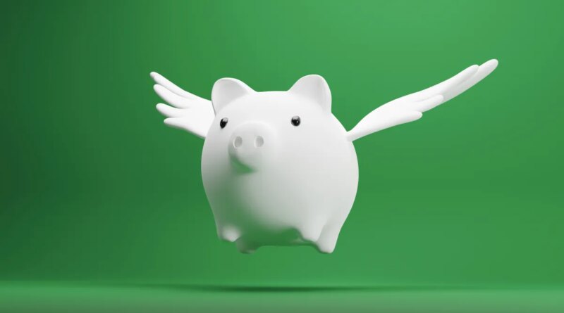 white piggy bank with wings on green background