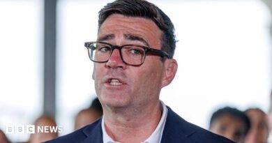 Andy Burnham in a suit and glasses. A close up of his face.