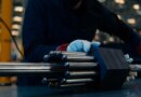 A person handles a nuclear fuel assembly.