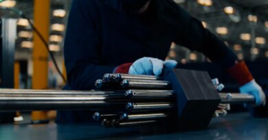 A person handles a nuclear fuel assembly.