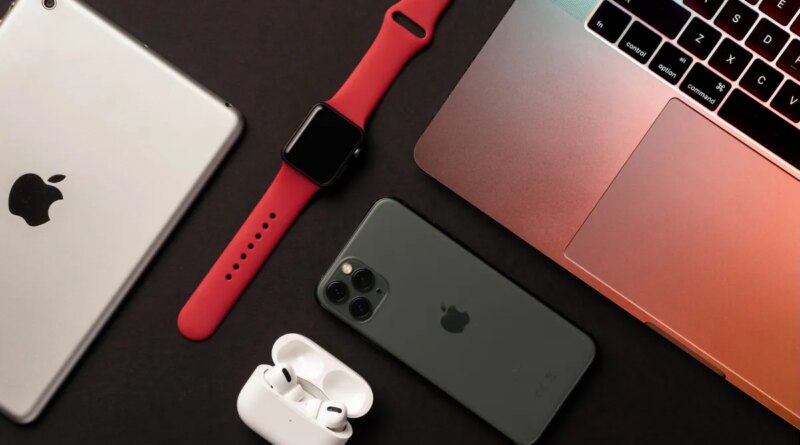 Flat Lay of different apple products on a dark grey background.