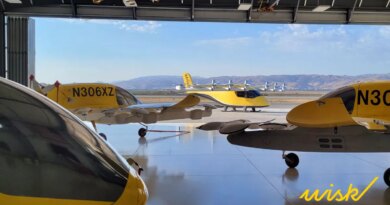 4 yellow wisk evtol in a hangar overlooking hills