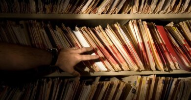 tons of medical records on a shelf in a darkened room