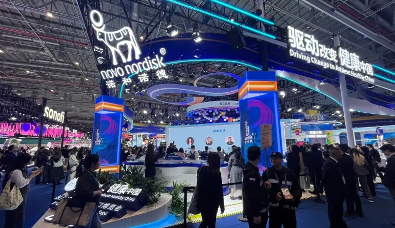 People walk past the Novo Nordisk booth at the 8th China International Import Expo (CIIE) in Shanghai, China November 6, 2025. REUTERS/Andrew Silver