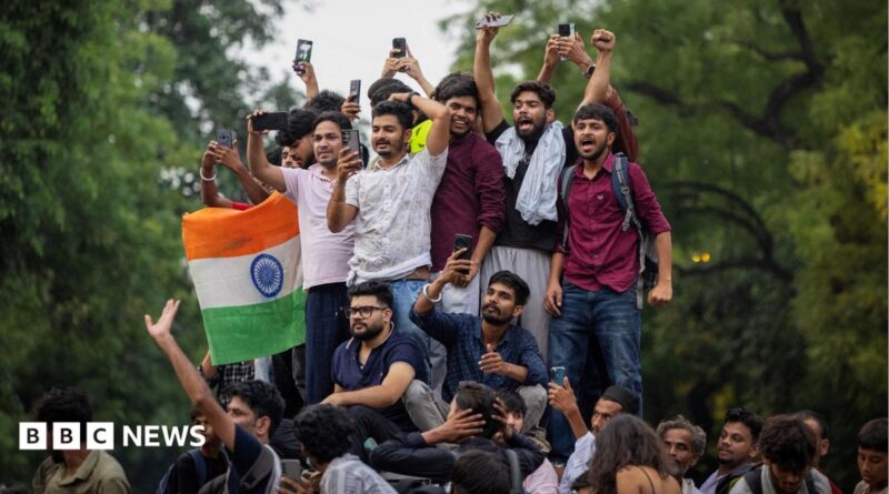 Abhijeet Dipke, head of the Cockroach Janta Party (CJP), celebrates with supporters who stand on an elevated platform holding their hands up in triumph