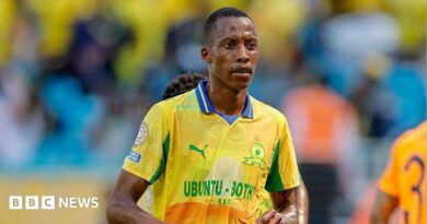 Footballer Divine Lunga is seen during a match in a yellow and green shirt