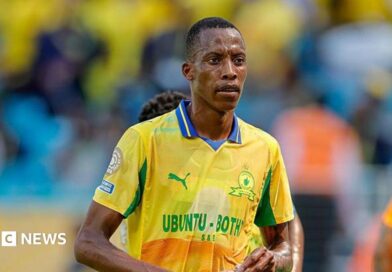 Footballer Divine Lunga is seen during a match in a yellow and green shirt