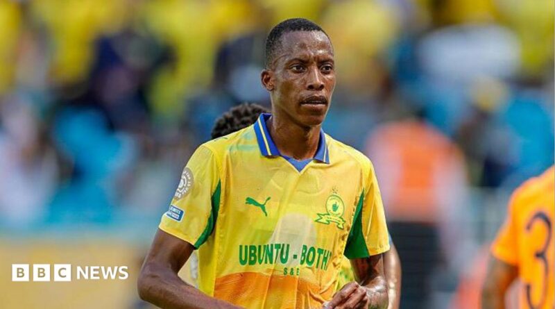 Footballer Divine Lunga is seen during a match in a yellow and green shirt