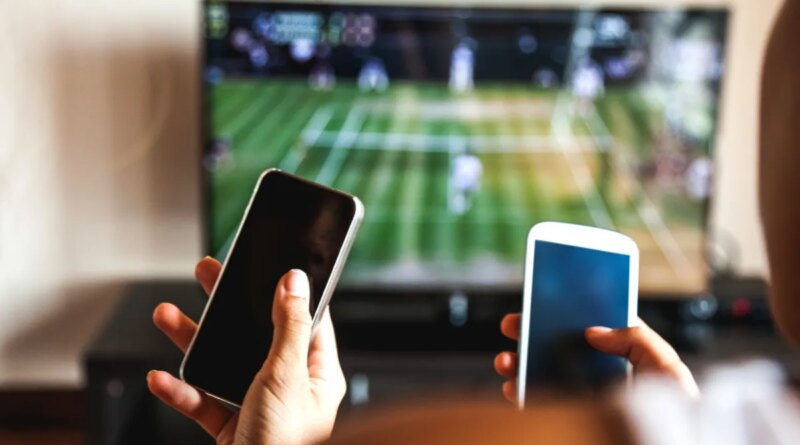 Friends using mobile phone during a tennis match on the TV.