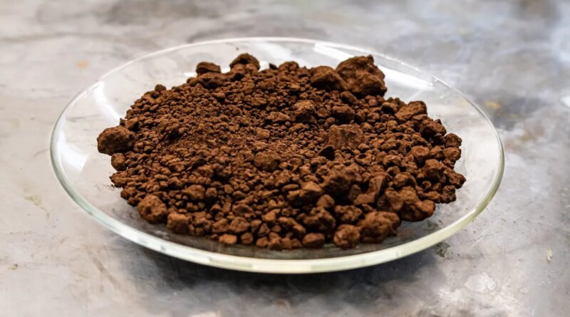 A plate of red mud sits on a lab workbench.