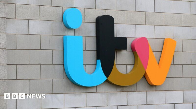 Mobile phone with an ITV 1 logo in black and yellow on the screen and blurred images of a streaming service in the background