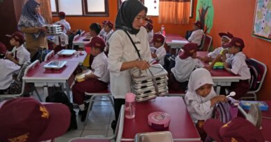 Members of school committee distribute meals to students during the kick off of President Prabowo Subianto's ambitious free meal program to feed children and pregnant women nationwide despite critics saying that its required logistics could hurt Indonesia's state finances and economy, at an elementary school in Depok, West Java, Indonesia, Monday, Jan. 6, 2025. (AP Photo/Dita Alangkara)