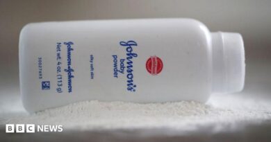A bottle of Johnson and Johnson Baby Powder is seen in a photo illustration placed on its side on top of some white baby powder