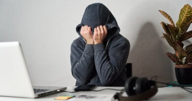 Man covering his face with a hood while working from home.