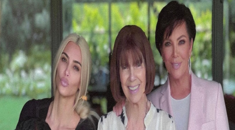 This photo shows Kim, her daughter, Mary Jo and Kris posing together smiling. They are standing by some bright pink flowers.
