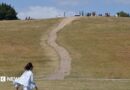 A woman walks along a dry Primrose Hill