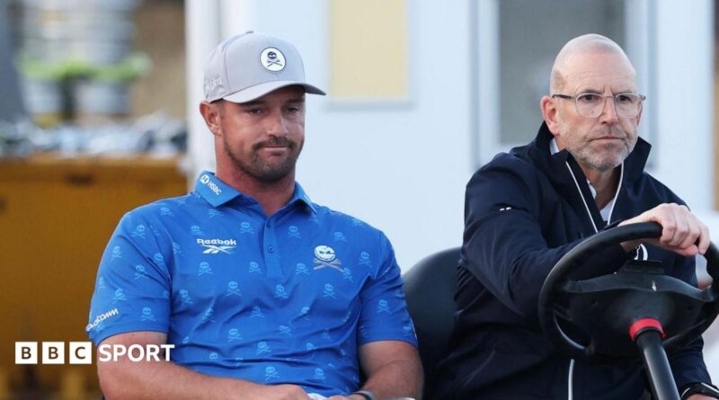 Bryson DeChambeau is driven on a buggy by an Open rules official