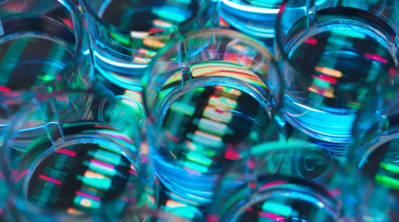 A human sample in a multi well plate ready for genetic analysis with a DNA sequence in the background