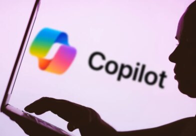 In this photo illustration, the Microsoft Copilot logo is seen in the background next to a silhouette of a person using a notebook.