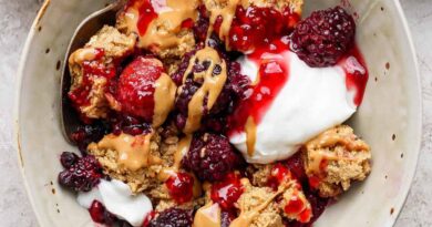 protein berry crumble served in a bowl with yogurt and peanut butter drizzle