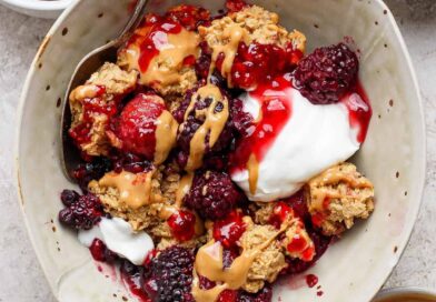 protein berry crumble served in a bowl with yogurt and peanut butter drizzle