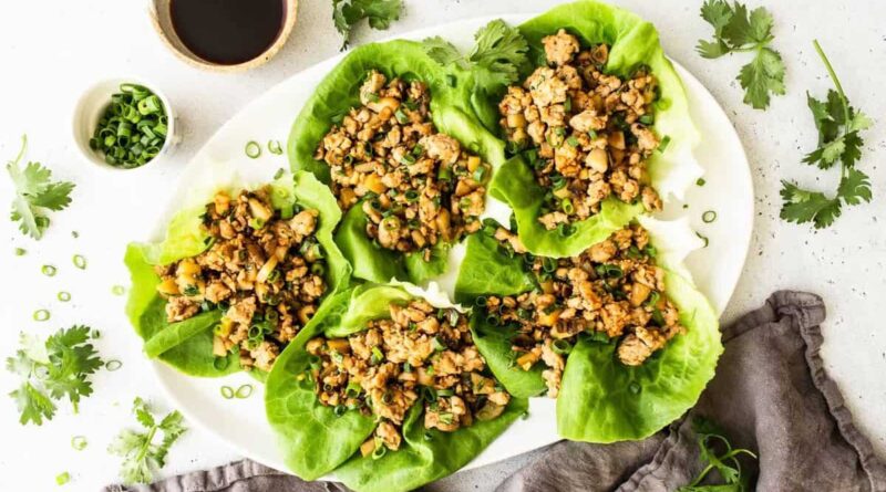 Chicken lettuce wraps on a serving platter with toppings.