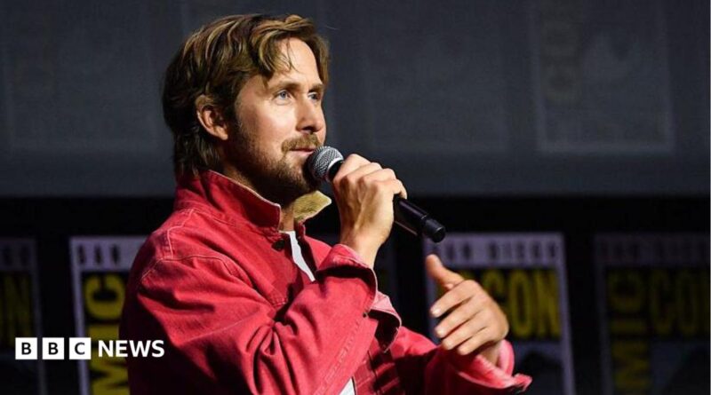 Ryan Gosling speaking into microphone on stage at San Diego Comic-Con