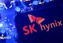 A screen displaying the SK Hynix logo posed above a computing motherboard