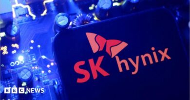 A screen displaying the SK Hynix logo posed above a computing motherboard