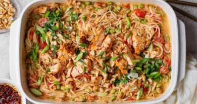 Salmon casserole with rice noodles, baked salmon chunks, cashews, green onions, cilantro, and chili crunch Boursin sauce in a white baking dish