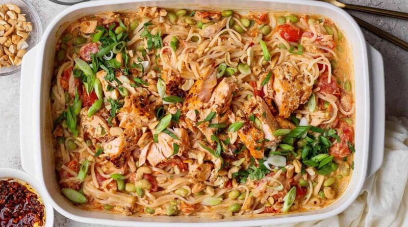 Salmon casserole with rice noodles, baked salmon chunks, cashews, green onions, cilantro, and chili crunch Boursin sauce in a white baking dish