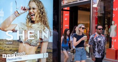 Peolep walking past a bus stop advertising for Chinese e-commerce fashion company Shein on 11 July 2026 in London.
