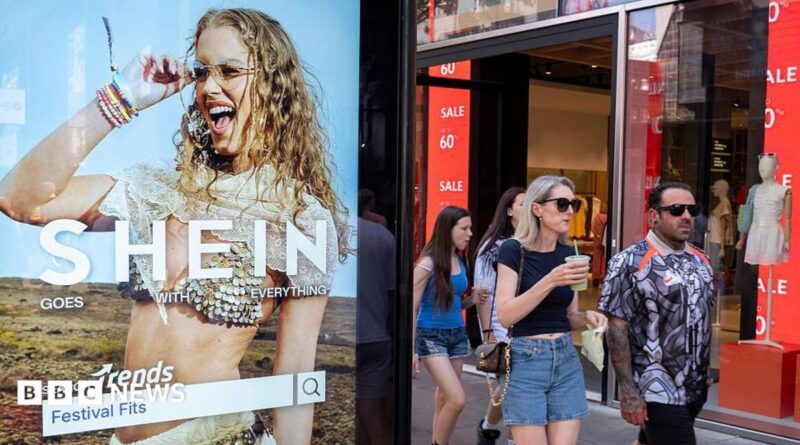 Peolep walking past a bus stop advertising for Chinese e-commerce fashion company Shein on 11 July 2026 in London.
