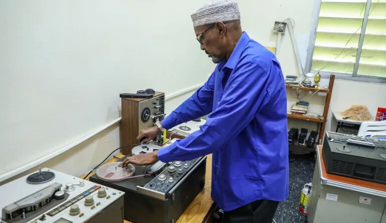 Abdiqadir Geedi Robleh cues up a tape, ready to hear a recording for the first time in years. [Abdimajid Abdillahi Farah/Al Jazeera]