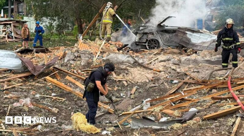 Emergency services clear through the rubble following a Russian missile strike just outside of Kyiv. Firefighters can be seen extinguishing a car fire in the background