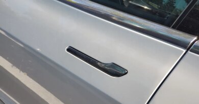Close-up of flush-mounted, retracting door handle on Tesla automobile.