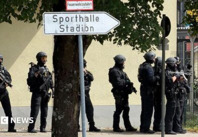 Police officers stand with guns outside a school in Germany.
