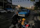A woman and girl cross a street in central Tehran on July 22, 2026