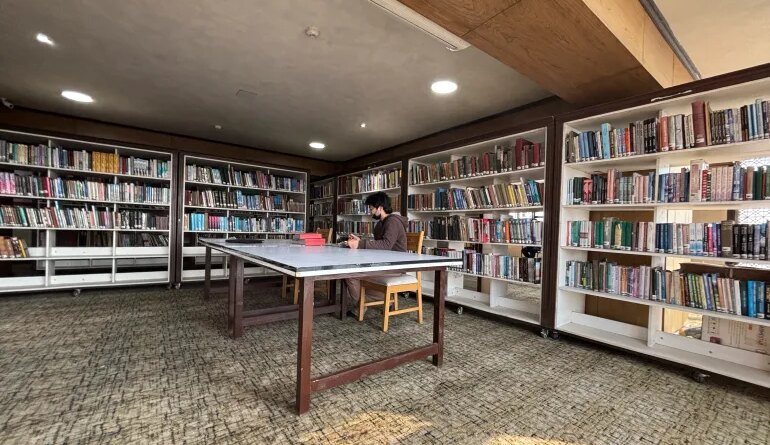 A man reads a book inside a library in Srinagar, February 17, 2025