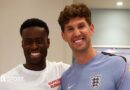 A picture of Guehi and Stones smiling at the camera at England's training camp in Kansas City