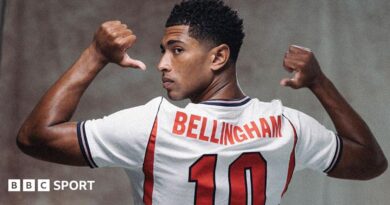 A picture of Jude Bellingham in a publicity shot wearing an England shirt, staring at the camera.